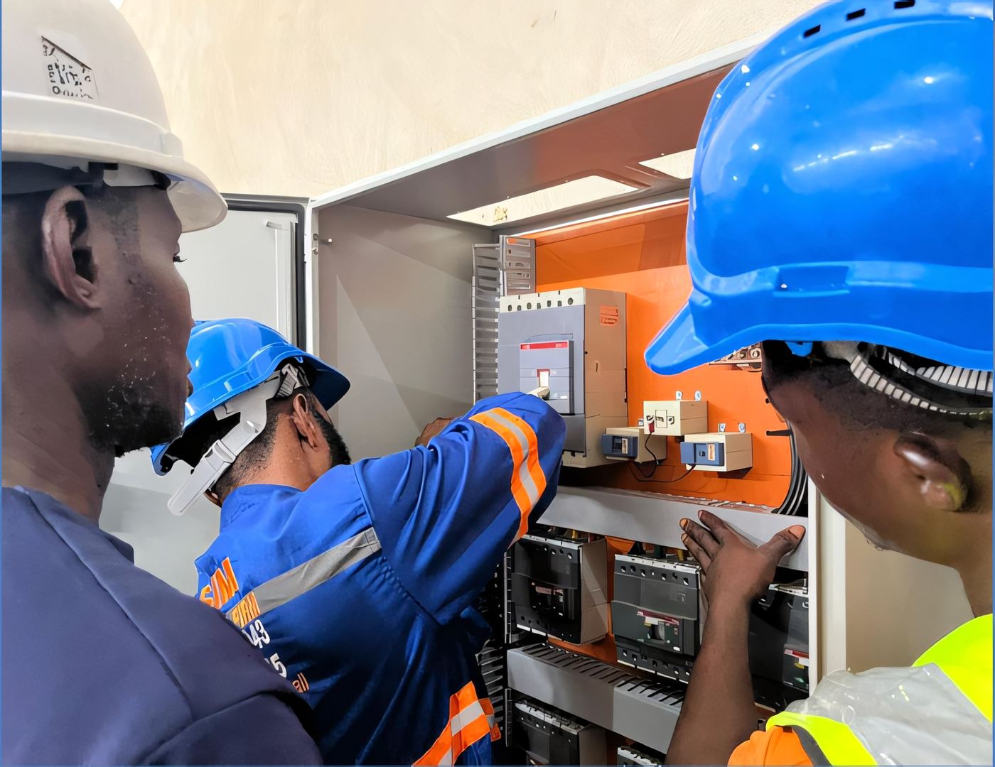 ELSIM technician inspecting a low-voltage breaker panel with the door open